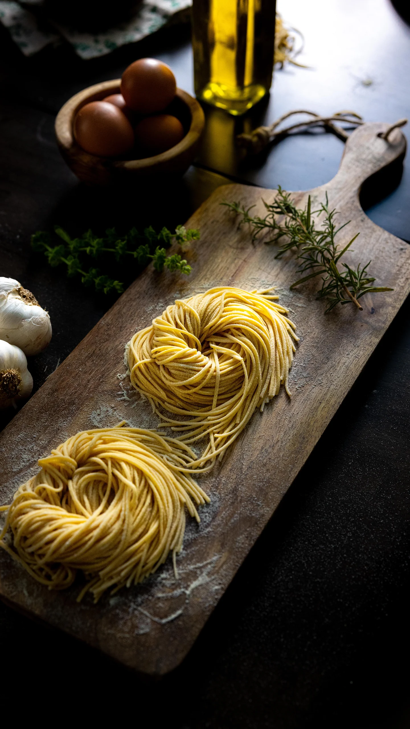 Nests of fresh pasta on a wooden board