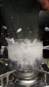Purple potato gnocchi being added to boiling water